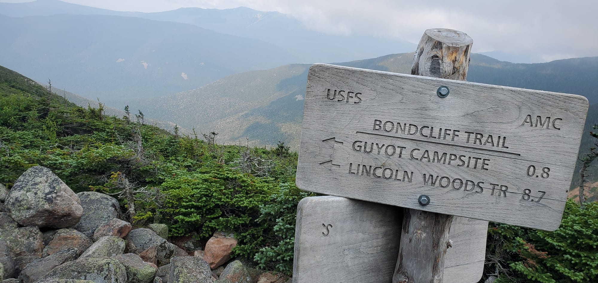 USFS and AMC trail sign on the Bondcliff Trail reading Guyot Campsite 0.8 and Lincoln Woods Tr 8.7